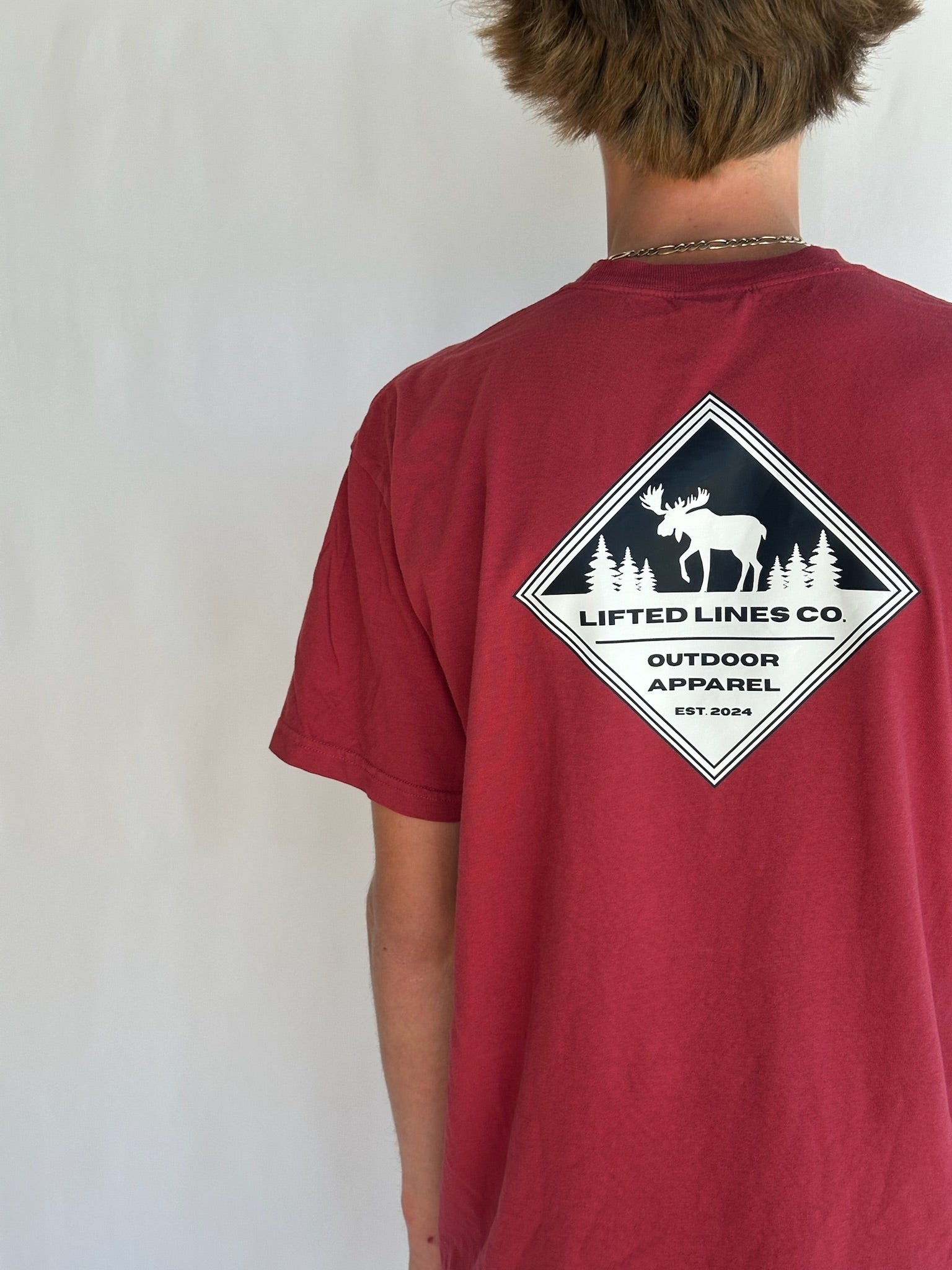 Red t-shirt with 'Lifted Lines Co' logo on the back, worn by a person against a plain background