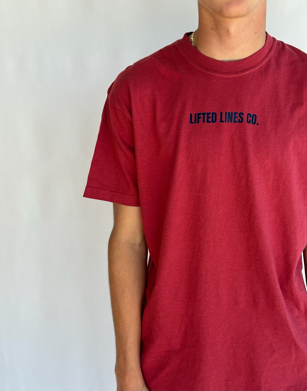 Red t-shirt with 'Lifted Lines Co.' text on a plain background