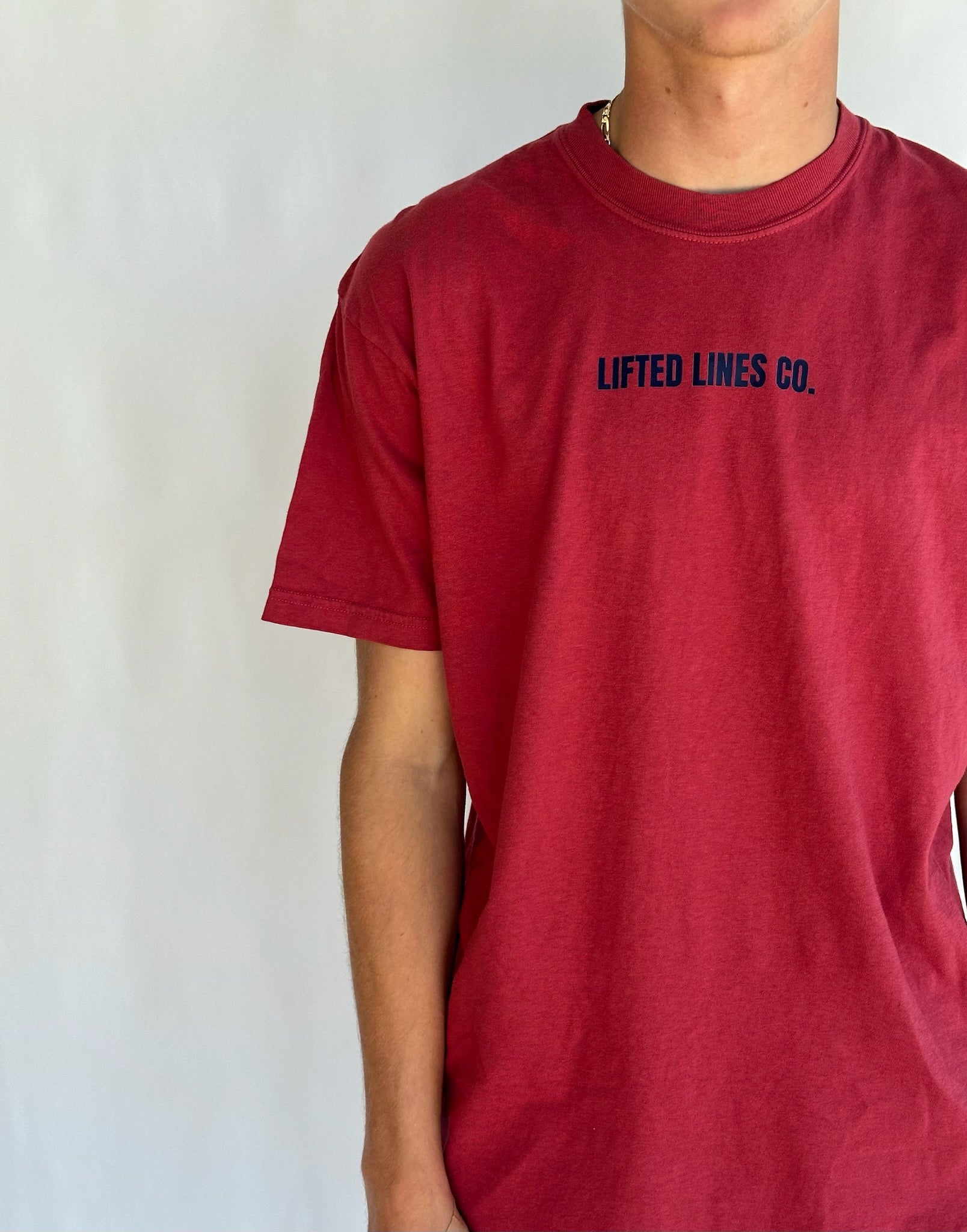 Red t-shirt with 'Lifted Lines Co.' text on a plain background