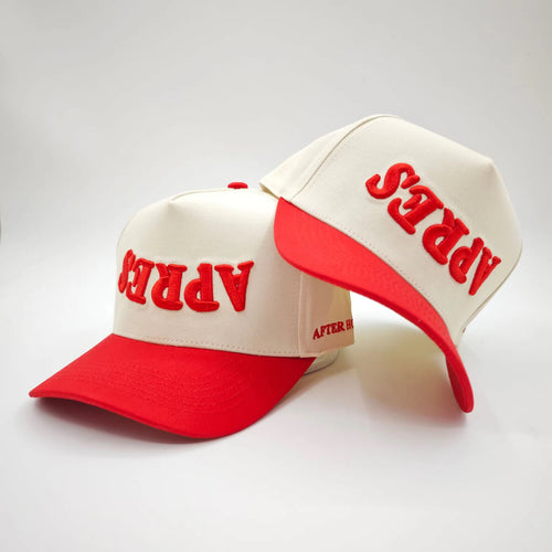Two red and white caps with 'APRES' text on a light gray background